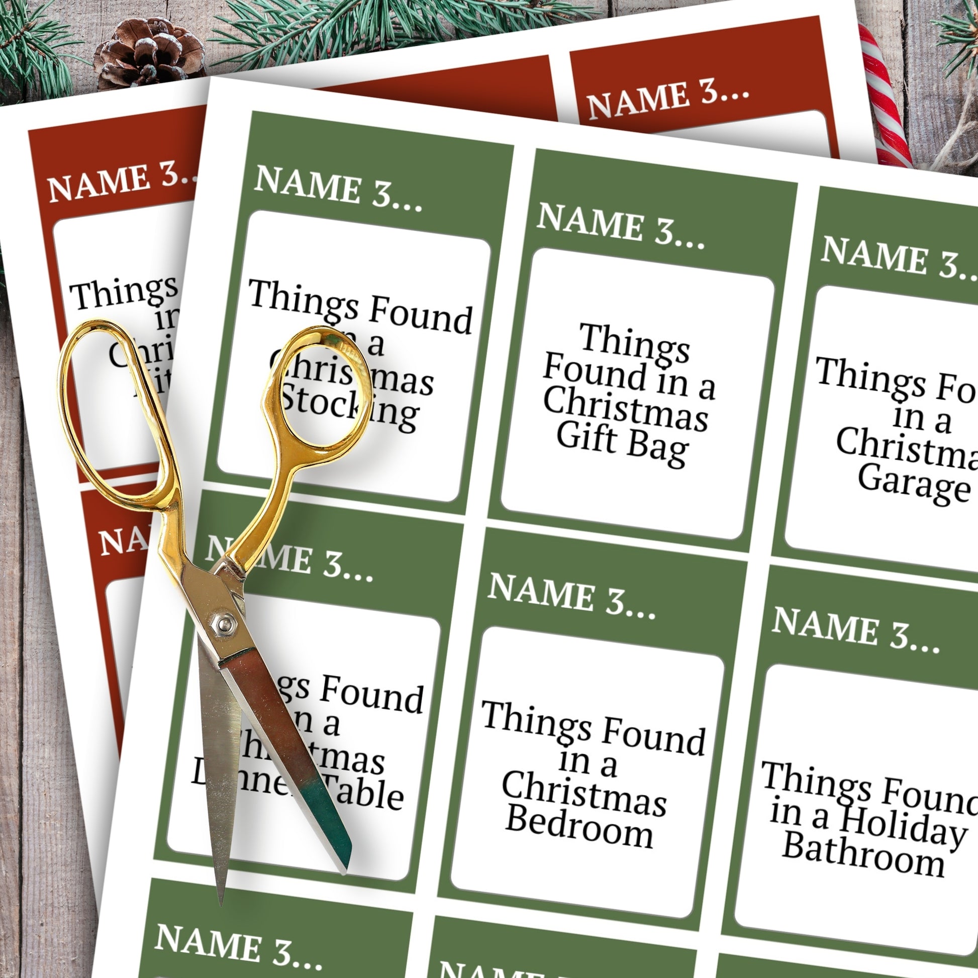 Two printed holiday gift tag sheets with green and white cards, one partially covered by gold scissors, on a rustic wood surface with pine branches and a candy cane.